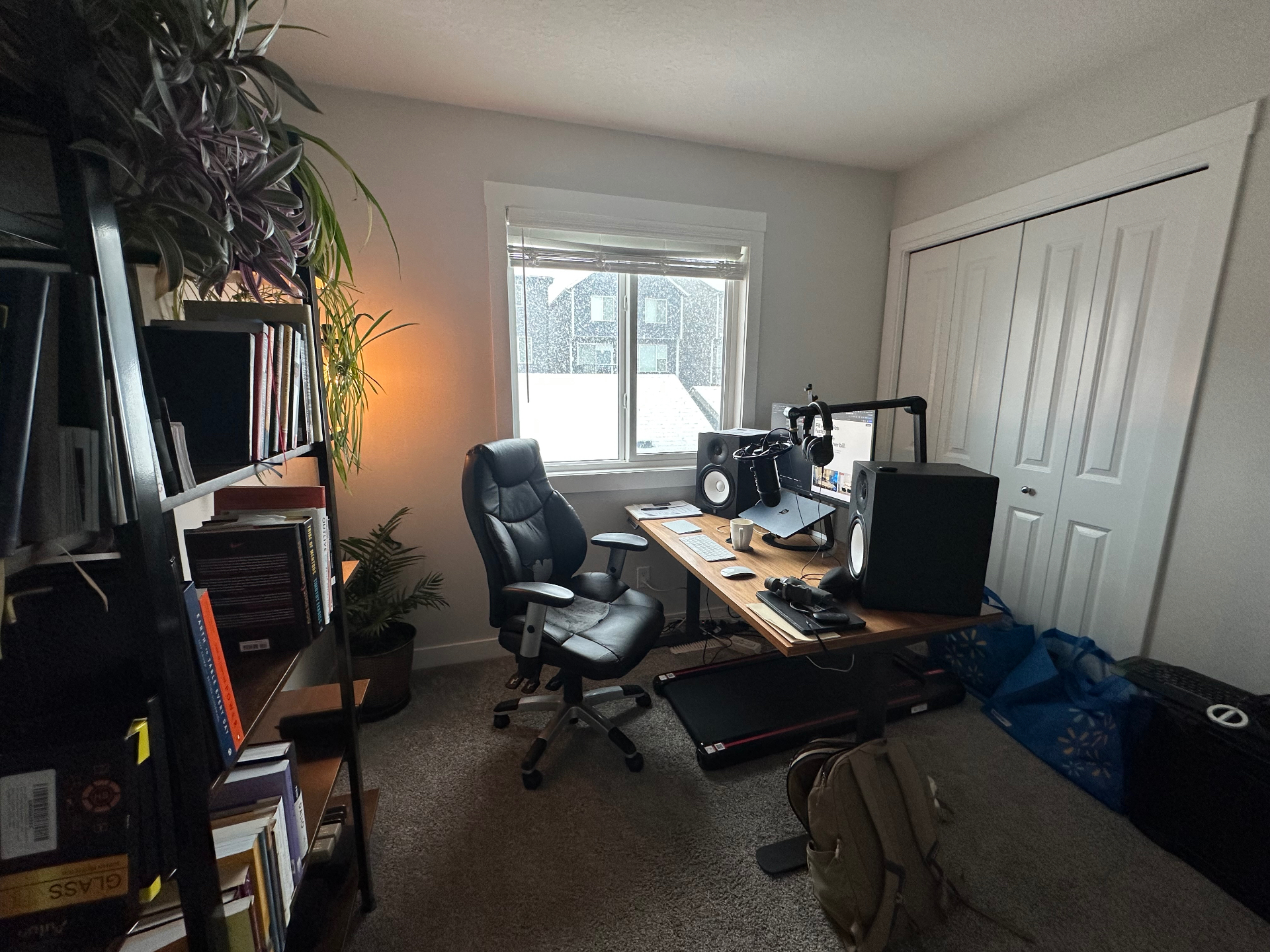 Original phone photo of a cluttered home office with bags and cables on the floor